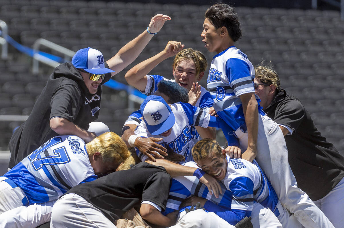 Basic players "dog pile" on the pitcher's mound in celebration of defeating Bishop Go ...