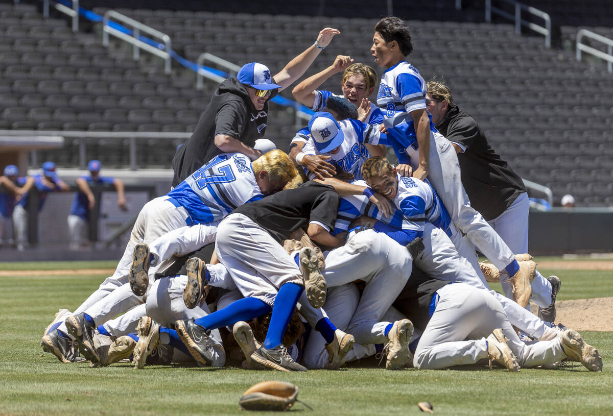 Basic players "dog pile" on the pitcher's mound in celebration of defeating Bishop Go ...