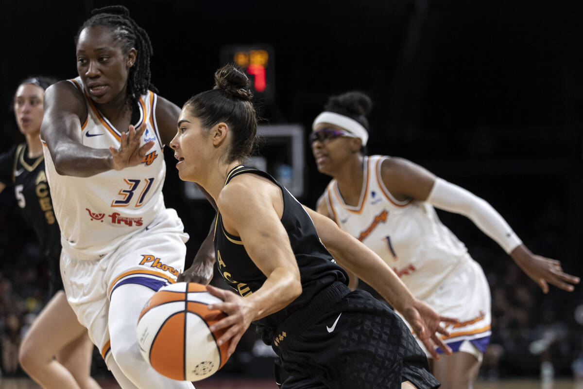 Las Vegas Aces guard Kelsey Plum, center, drives around Phoenix Mercury center Tina Charles (31 ...