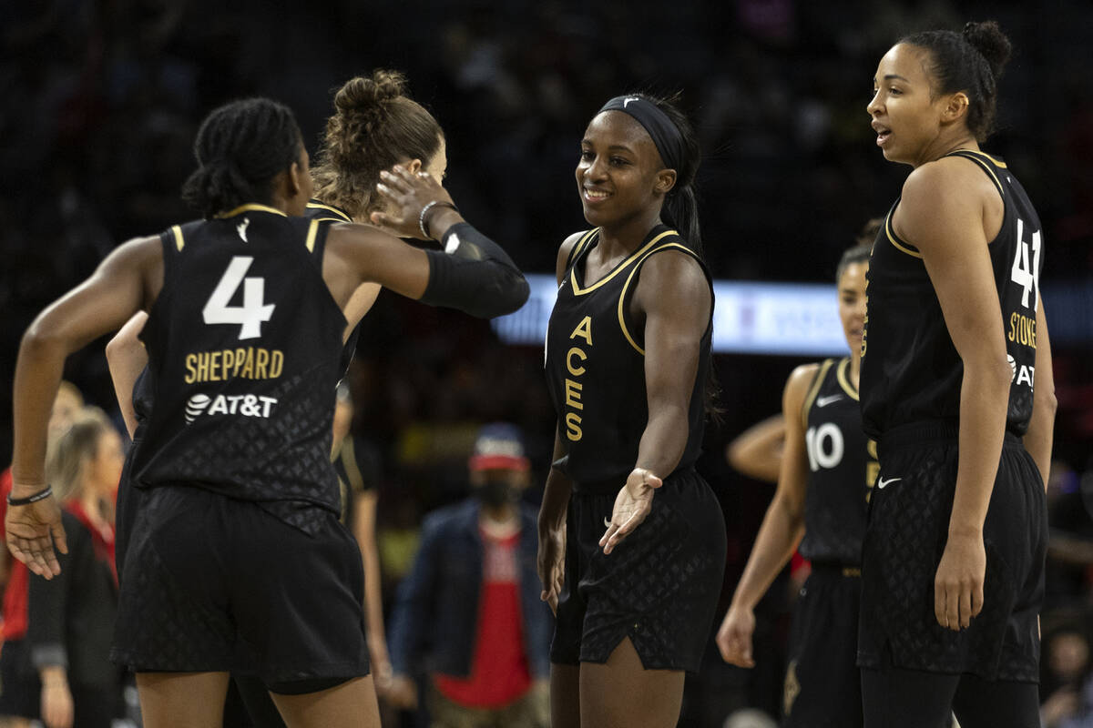Las Vegas Aces guard Aisha Sheppard (4) slaps hands with guard Jackie Young, center, during the ...