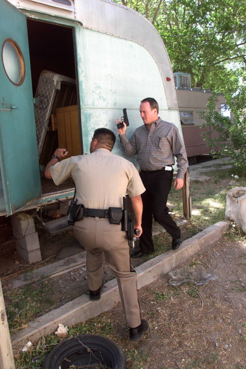 Las Vegas police officer William Umana, left, and Detective Don Tremel search a vacant trailer ...