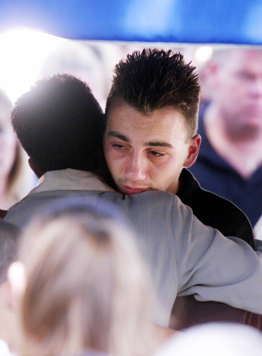 Chris Gautier, 17, hugs a loved one during funeral services for his mother Kim and brother Anth ...