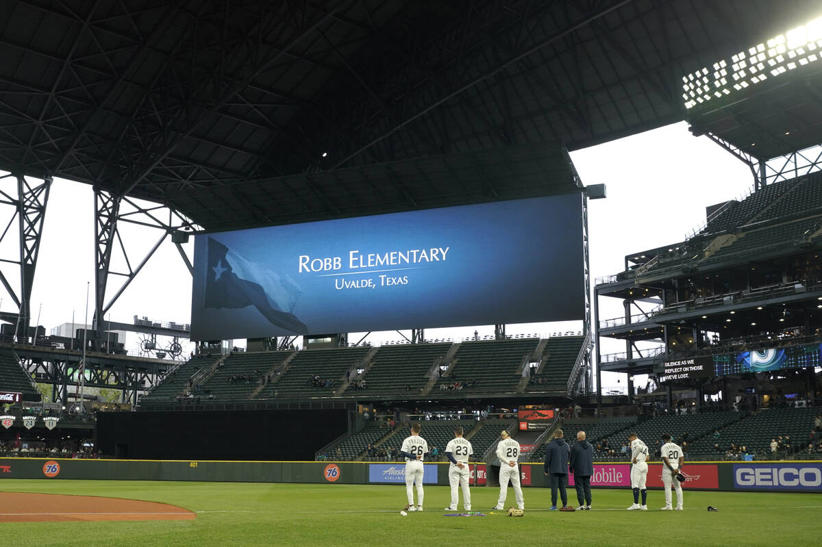 Seattle Mariners players stand on the field before a baseball game against the Oakland Athletic ...