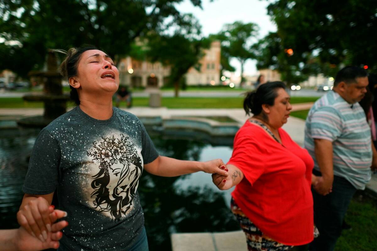 Kladys Castellón prays during a vigil for the victims of a mass shooting at Robb Elementary Sc ...