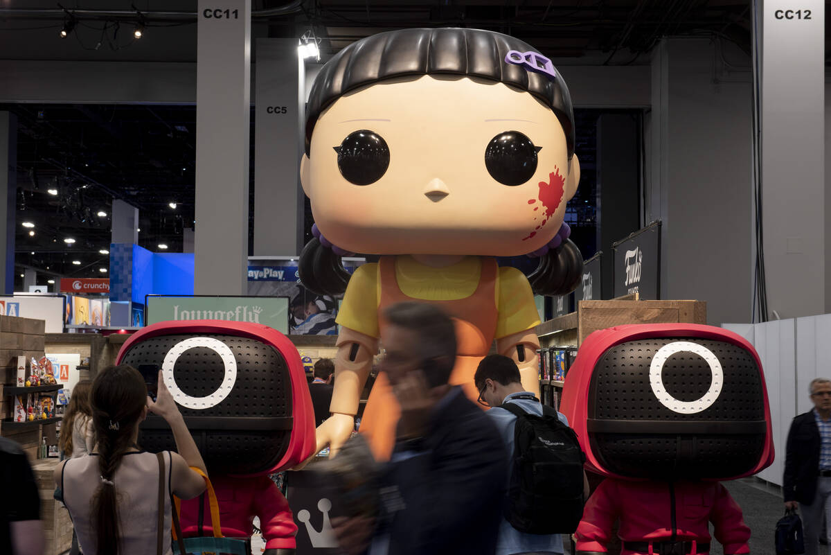People walk past the Funko booth displaying larger than live versions of the companies popular ...