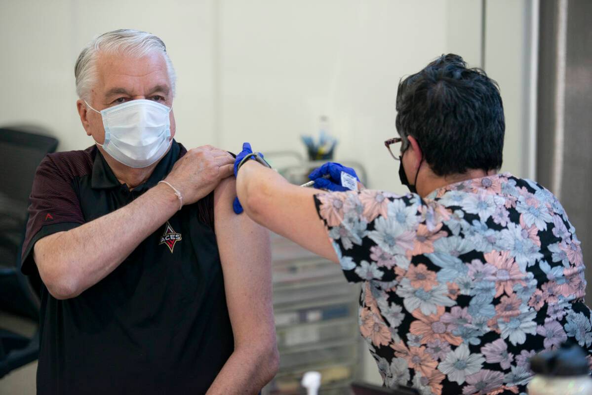 Gov. Steve Sisolak receives his second COVID-19 booster from nurse KJ Dionisio at the Southern ...