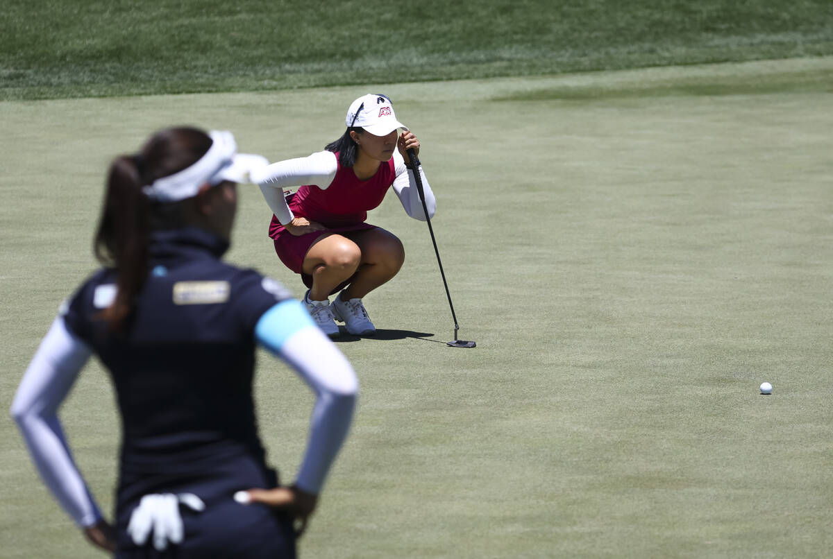 Danielle Kang lines up a putt shot at the 12th hole as Kelly Tan, left, looks on during the fir ...