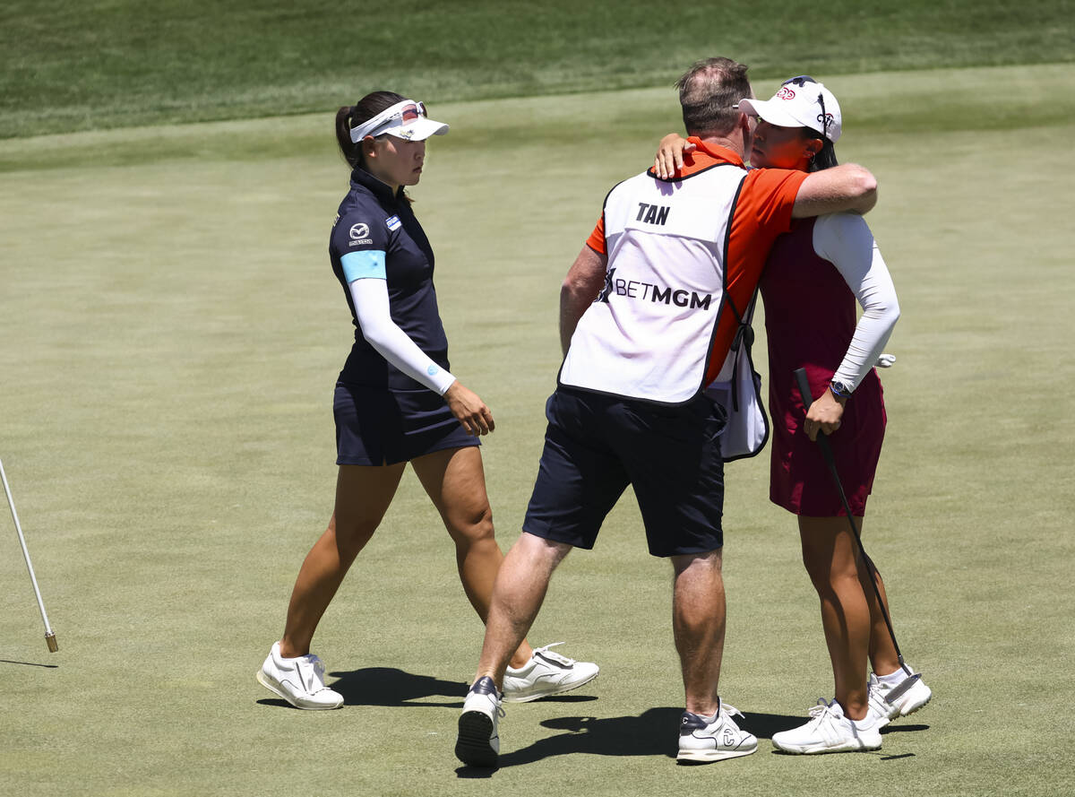 Kelly Tan, left, and her caddy embrace Danielle Kang after Kang lost to Tan at the 12th hole du ...