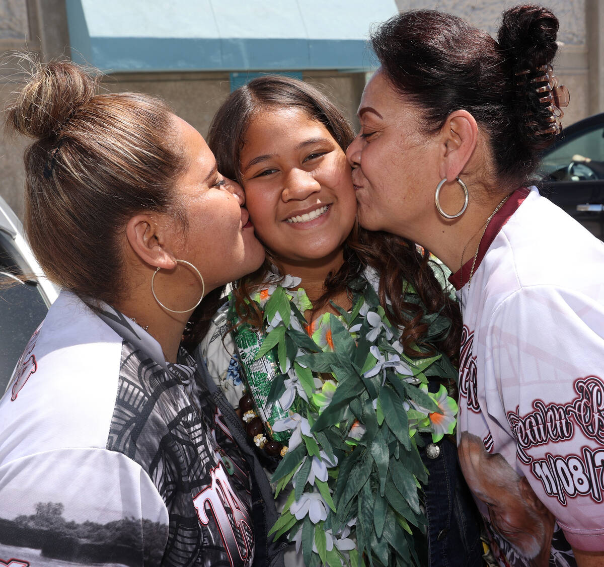 Fifth grade graduate Leilah Afe, 11, with her mother Natasha Mariota, left, and grandmother Lel ...
