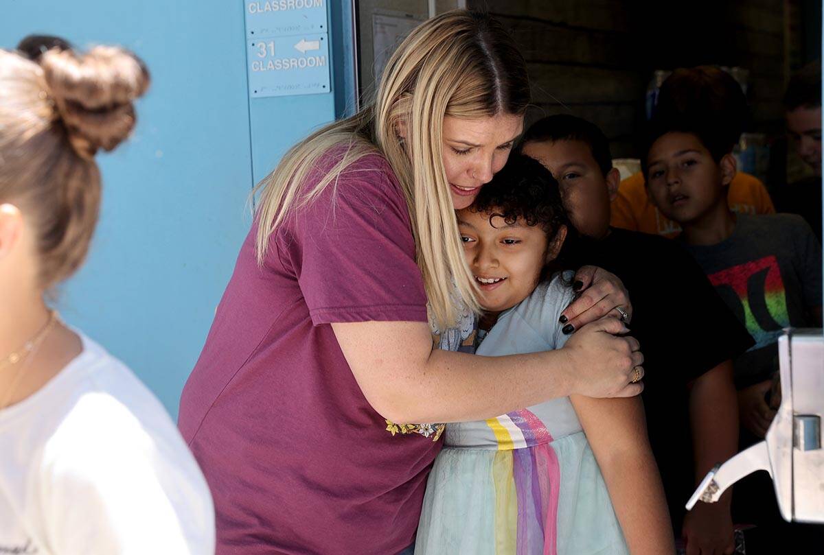 Third grade teacher Lindsey Shultzman hugs Perla Contreas, 9, on the last day of school at Don ...