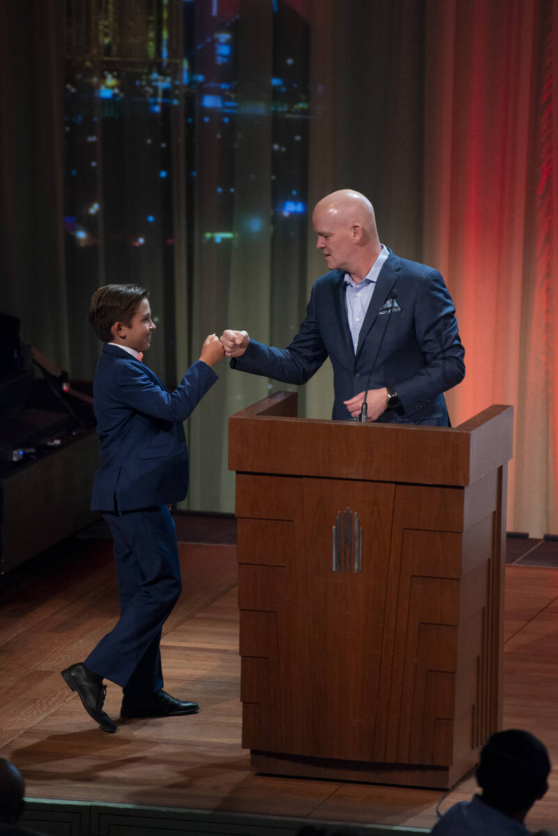 Howard Wasden Elementary fourth grader Alan Powell, left, fist bumps emcee Chet Buchanan at the ...