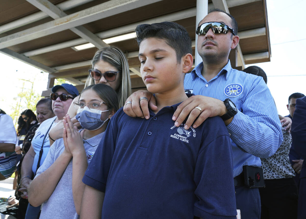 Omahar Padillo holds on to his son Omahar Jr., 12, during a community prayer Wednesday, May 25, ...