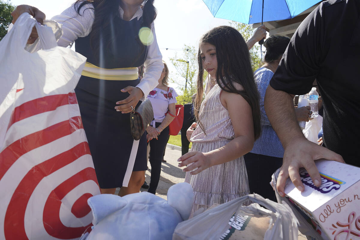Madeleine Rigney, 9, places a stuffed bear to be donated to the shooting victims at Robb Elemen ...