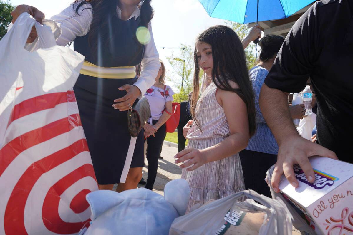 Madeleine Rigney, 9, places a stuffed bear to be donated to the shooting victims at Robb Elemen ...
