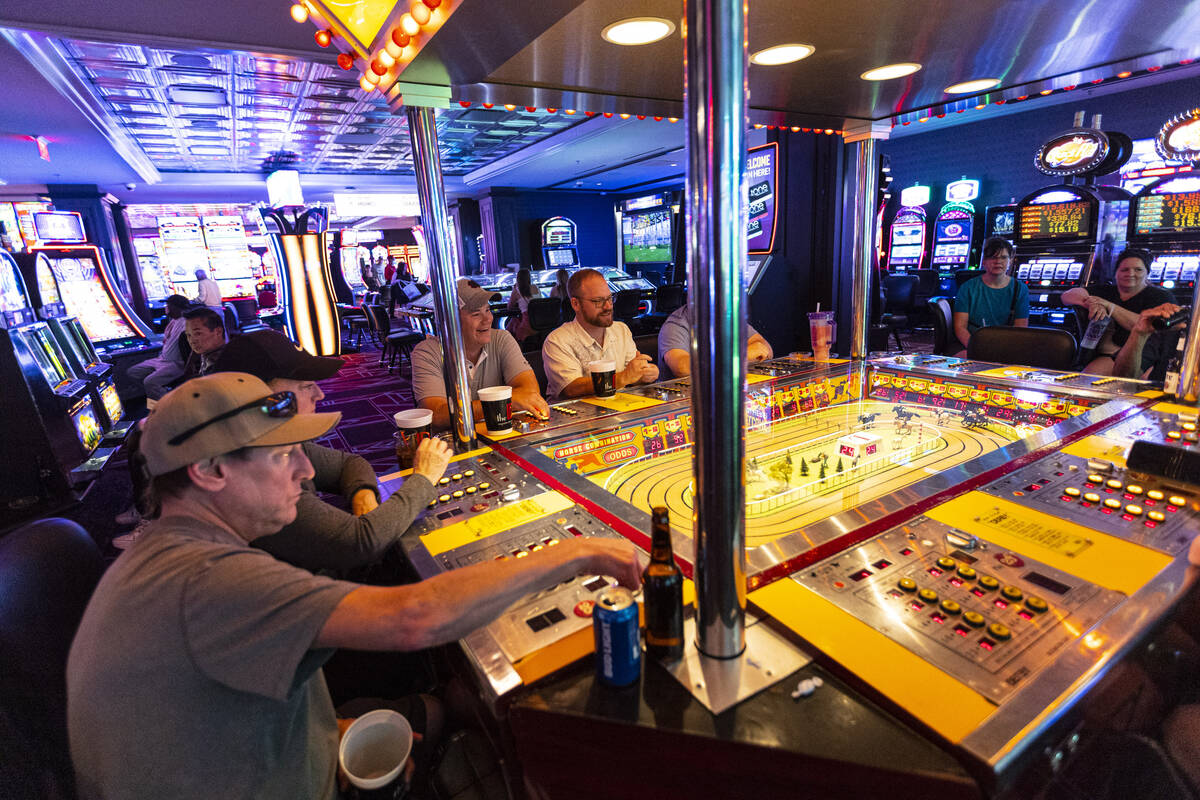 Andy Sheehan, left, of Henderson, plays the coin-operated Sigma Derby game at the D Las Vegas o ...