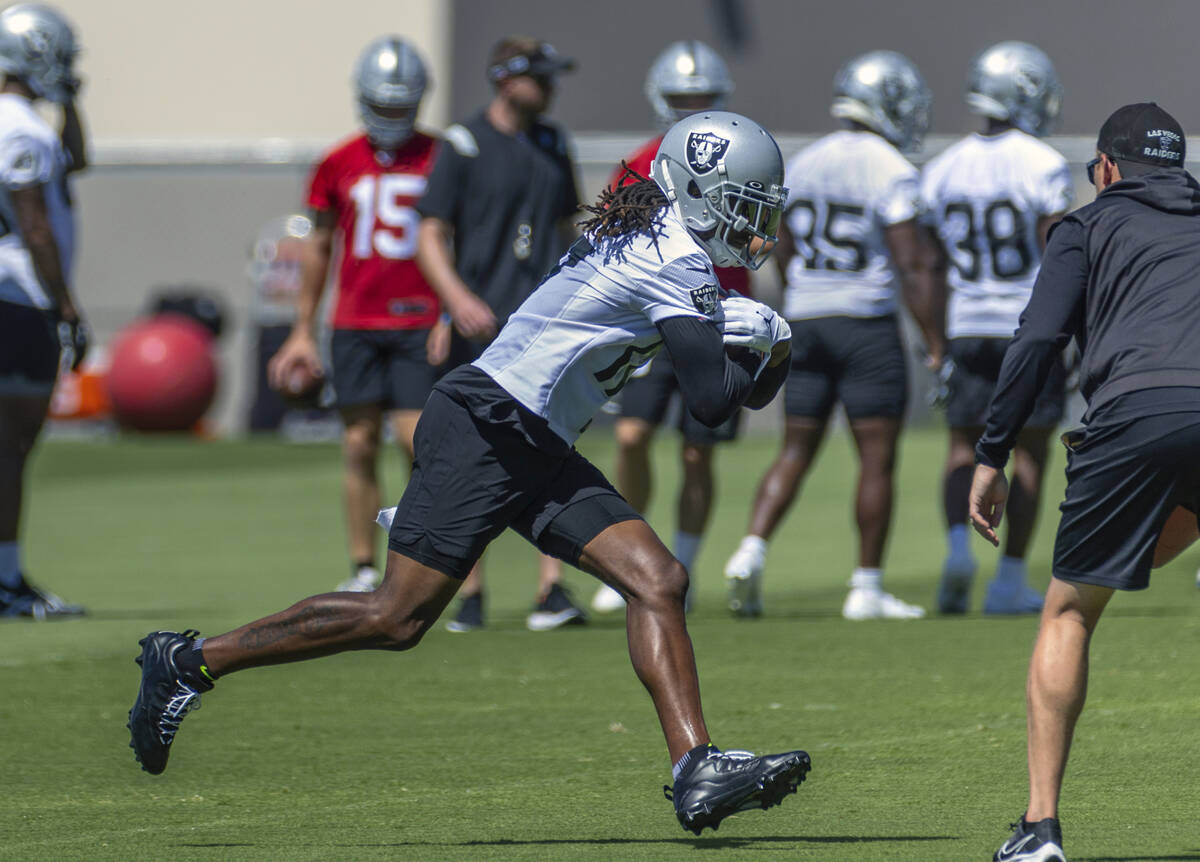 Raiders wide receiver Davante Adams (17) runs after a catch pulls in a pass during practice at ...