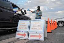 In this Nov. 2, 2020, file photo, a county worker collects mail-in ballots in a drive-thru mail ...