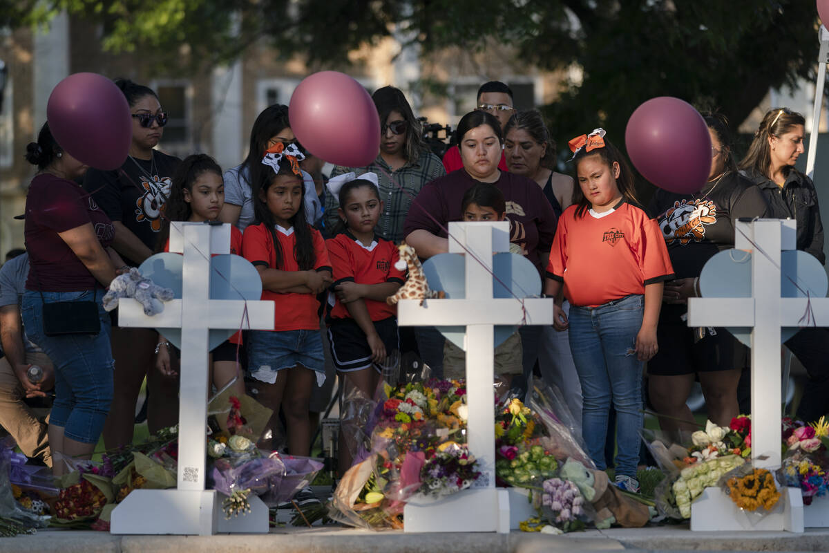 People gather at a memorial site to pay their respects for the victims killed in this week's el ...