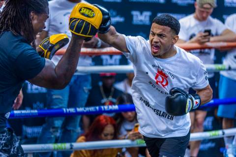 Boxer Rolando Romero, right, hits the hand pads with his trainer during media day workouts at t ...
