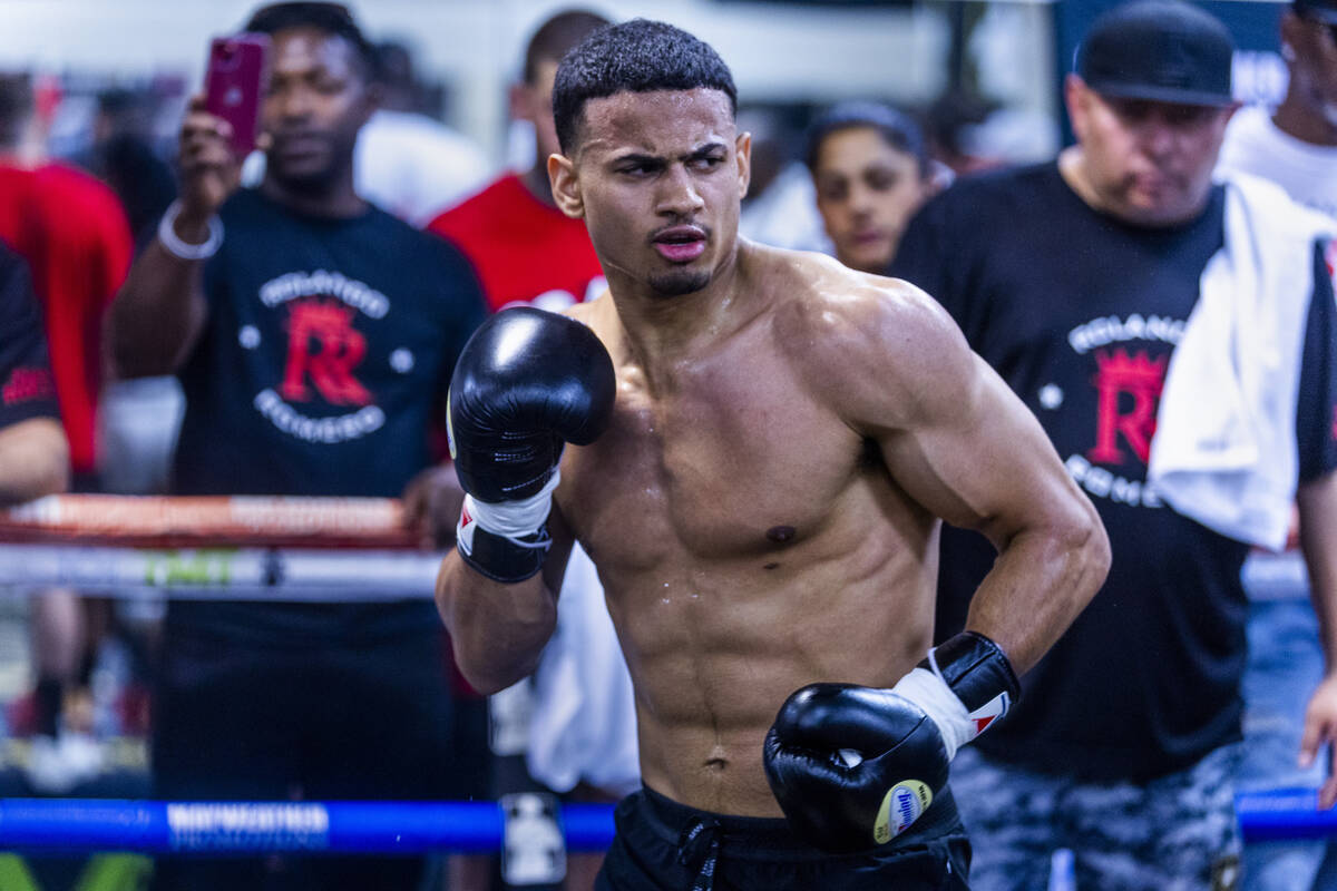 Boxer Rolando Romero looks to throw a punch with trainer during media day workouts at the Maywe ...