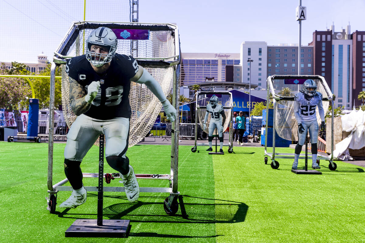 (LtoR) Cutouts of Raiders players Max Crosby, Nate Hobbs and Tre'von Moehrig adorn passing bask ...
