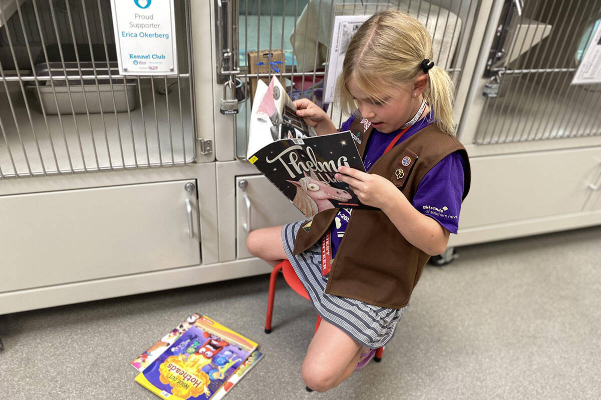 A member of Brownies Troop 29 in Henderson reads to sheltered animals at The Animal Foundation ...