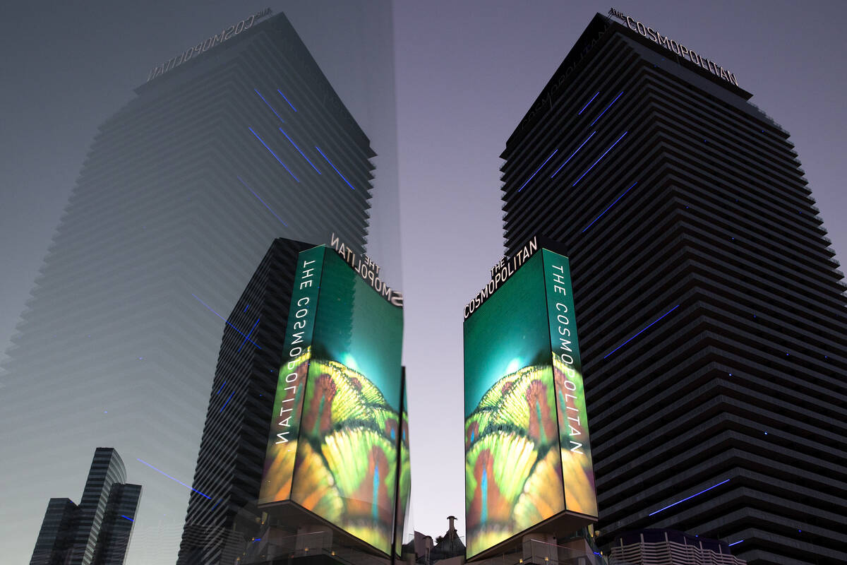 The Cosmopolitan of Las Vegas is reflected in the glass of a pedestrian bridge on Wednesday, Ju ...