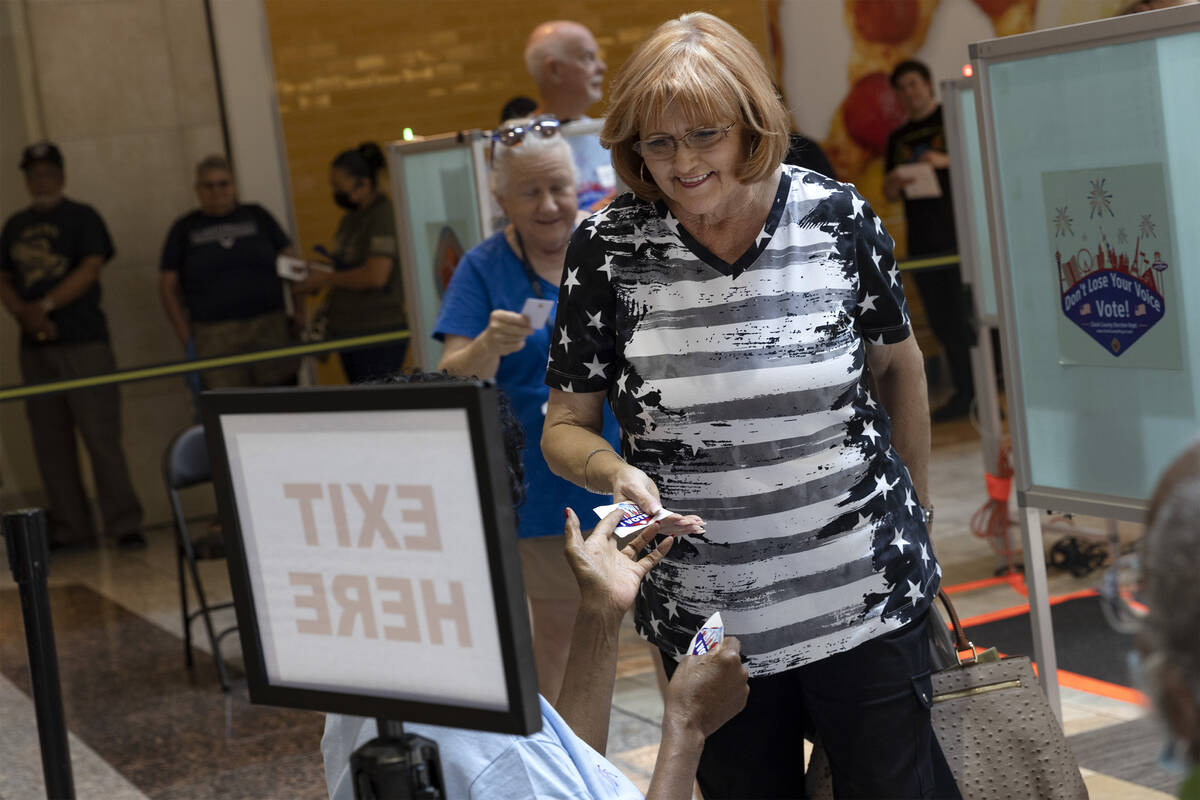 Cheryl Hartle, of Las Vegas, receives a sticker after casting her ballot during early voting at ...
