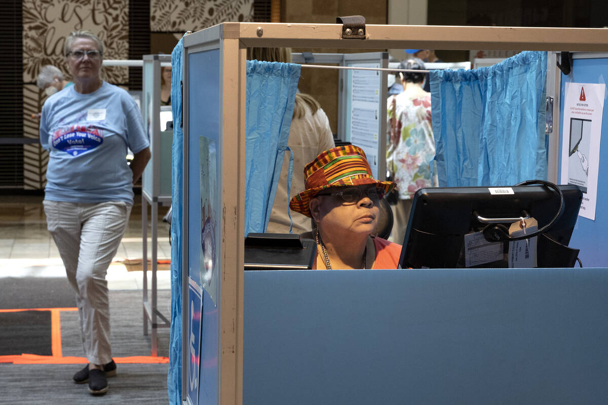 Karen L. Ballard, right, of Las Vegas, casts her ballot during early voting at Galleria at Suns ...