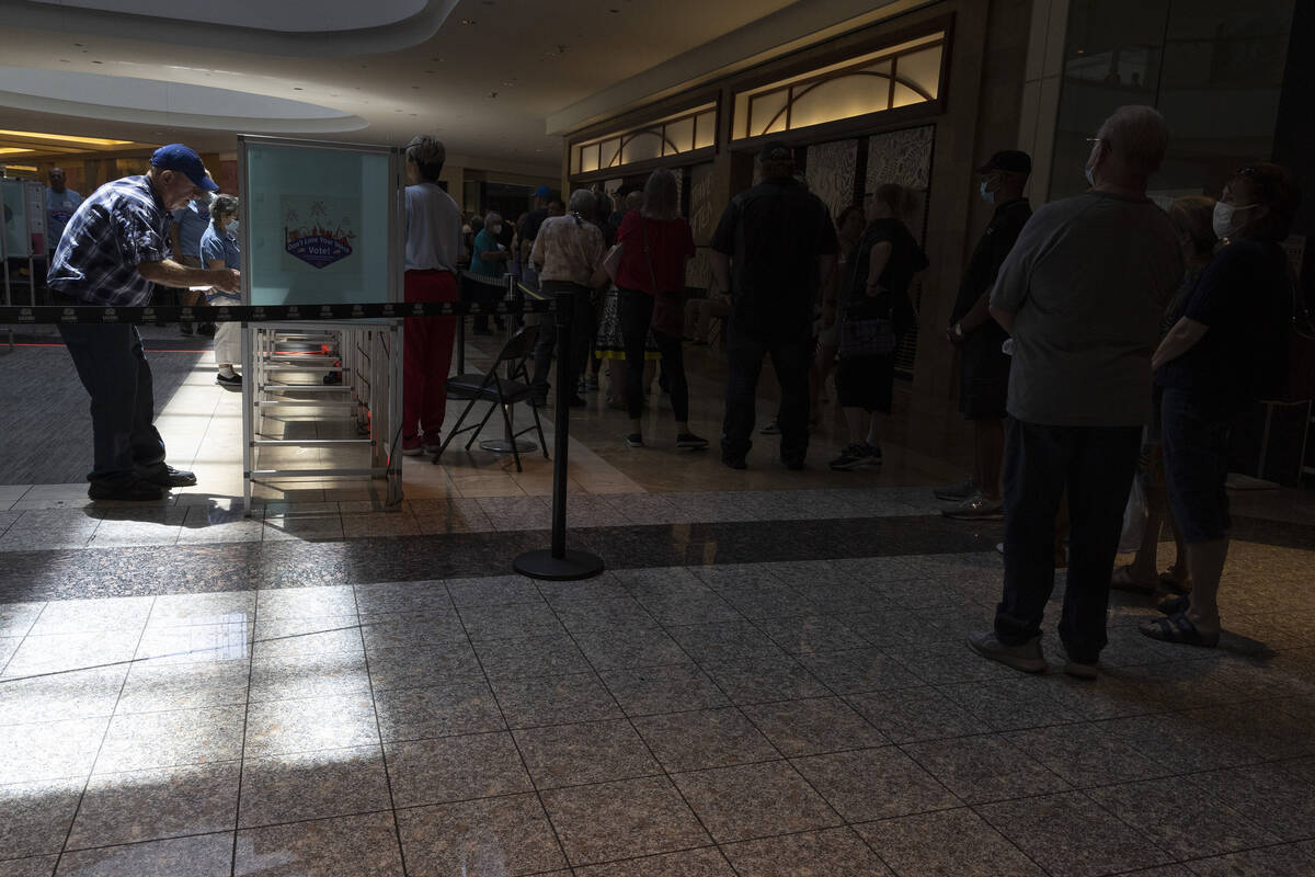 Early voters cast their ballots while the line wraps around the polling site at Galleria at Sun ...