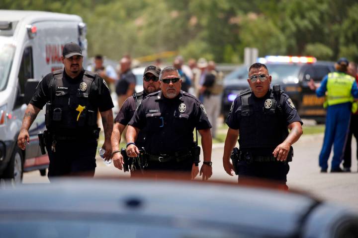 Police walk near Robb Elementary School following a shooting, Tuesday, May 24, 2022, in Uvalde, ...