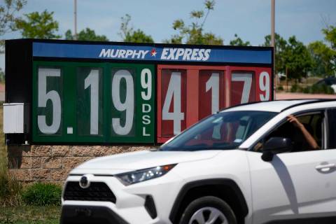 Gasoline prices are displayed outside a convenience store as a motorist drives by, Thursday, Ma ...