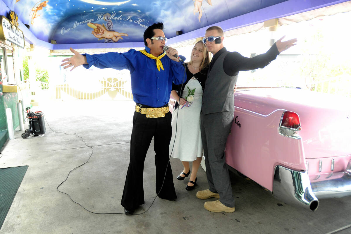 Emily and Sheldon Smith sing along with Elvis impersonator Jesse Garon during their wedding ren ...