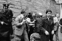 FILE - In this March 30, 1981 file photo, Secret Service agents and police officers swarm a gun ...