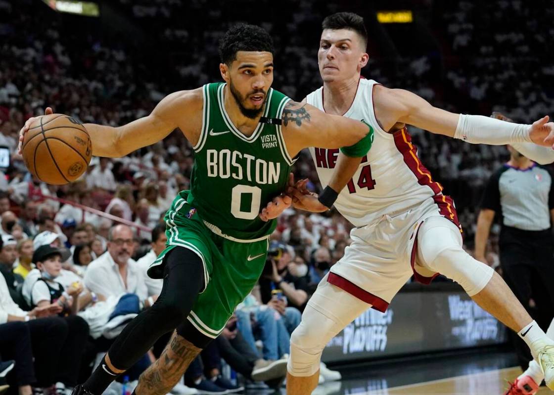 Boston Celtics forward Jayson Tatum (0) dribbles the ball as Miami Heat guard Tyler Herro (14) ...
