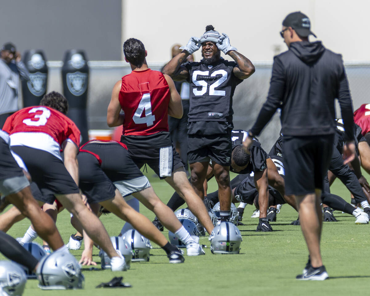 Raiders linebacker Denzel Perryman (52) chats with quarterback Derek Carr (4) as they stretch d ...