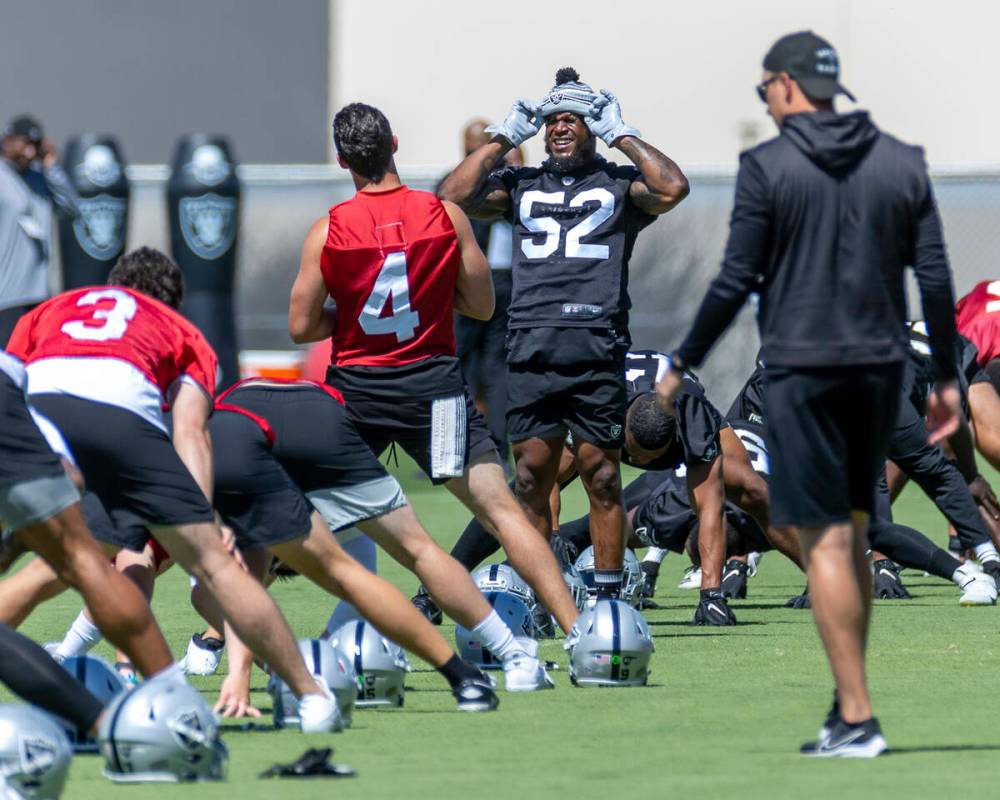 Raiders linebacker Denzel Perryman (52) chats with quarterback Derek Carr (4) as they stretch d ...
