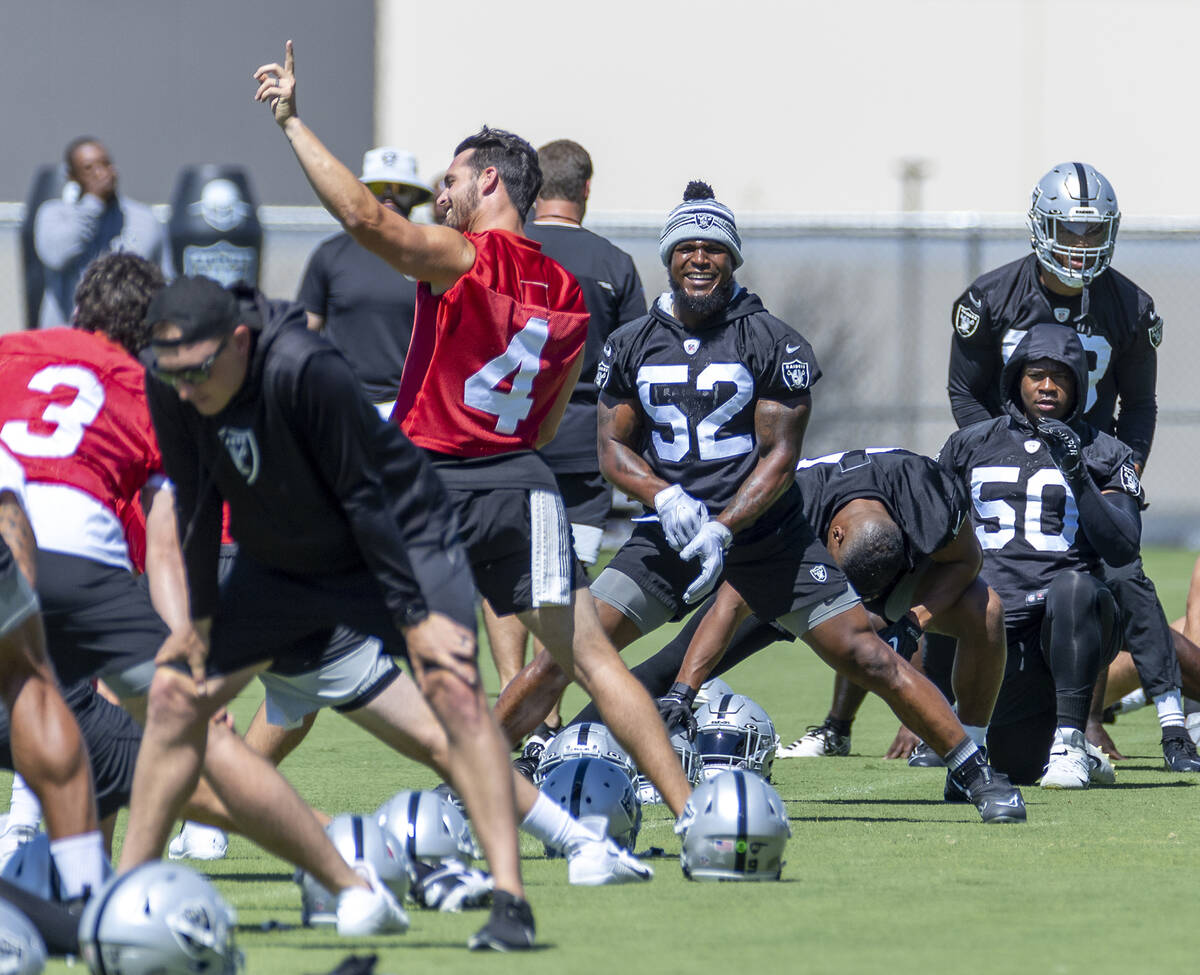 Raiders linebacker Denzel Perryman (52) laughs while listening to quarterback Derek Carr (4) ta ...