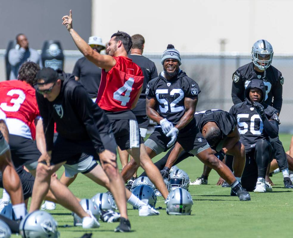 Raiders linebacker Denzel Perryman (52) laughs while listening to quarterback Derek Carr (4) ta ...