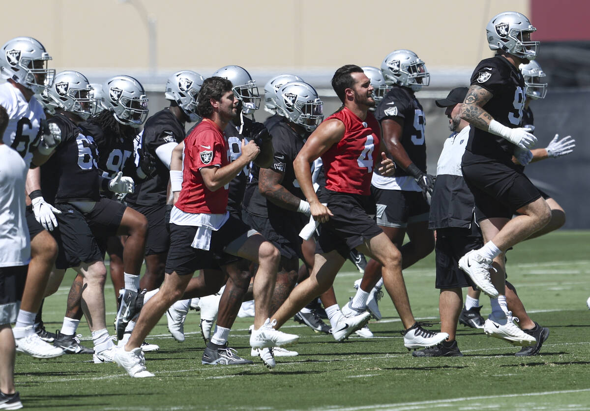 Raiders quarterbacks Jarrett Stidham, left, in red, Derek Carr (4) and defensive end Maxx Crosb ...