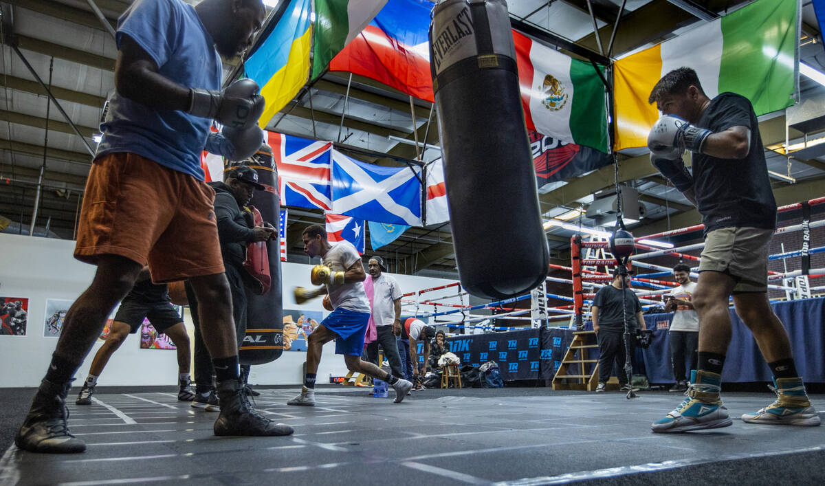 WBC lightweight boxer Devin Haney, center rear, throws a punch on a heavy bag as other boxers p ...