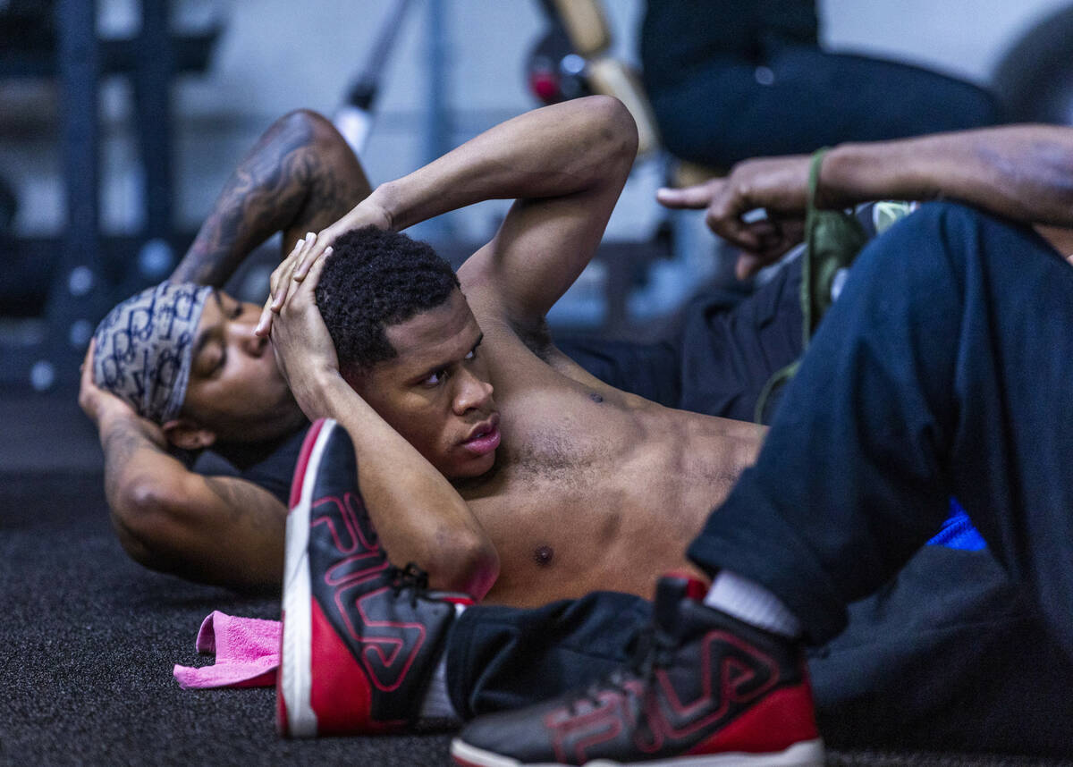 WBC lightweight boxer Devin Haney, near, and boxer Amari Jones work on their cores during a wor ...