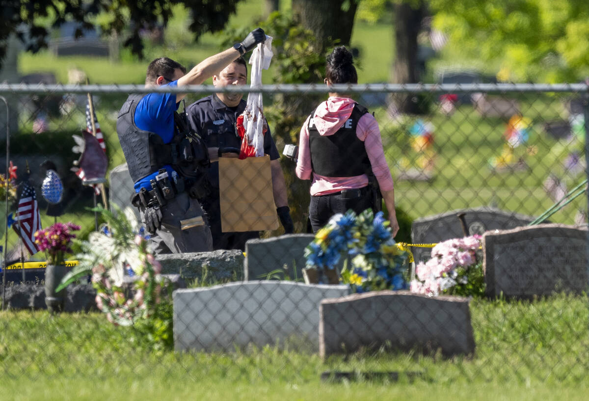 Law enforcement examine a bloody garment while working at the scene of a shooting Thursday, Jun ...