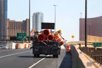 Crews work to remove orange safety barrels along Interstate 15 near the Sahara Avenue exit on M ...