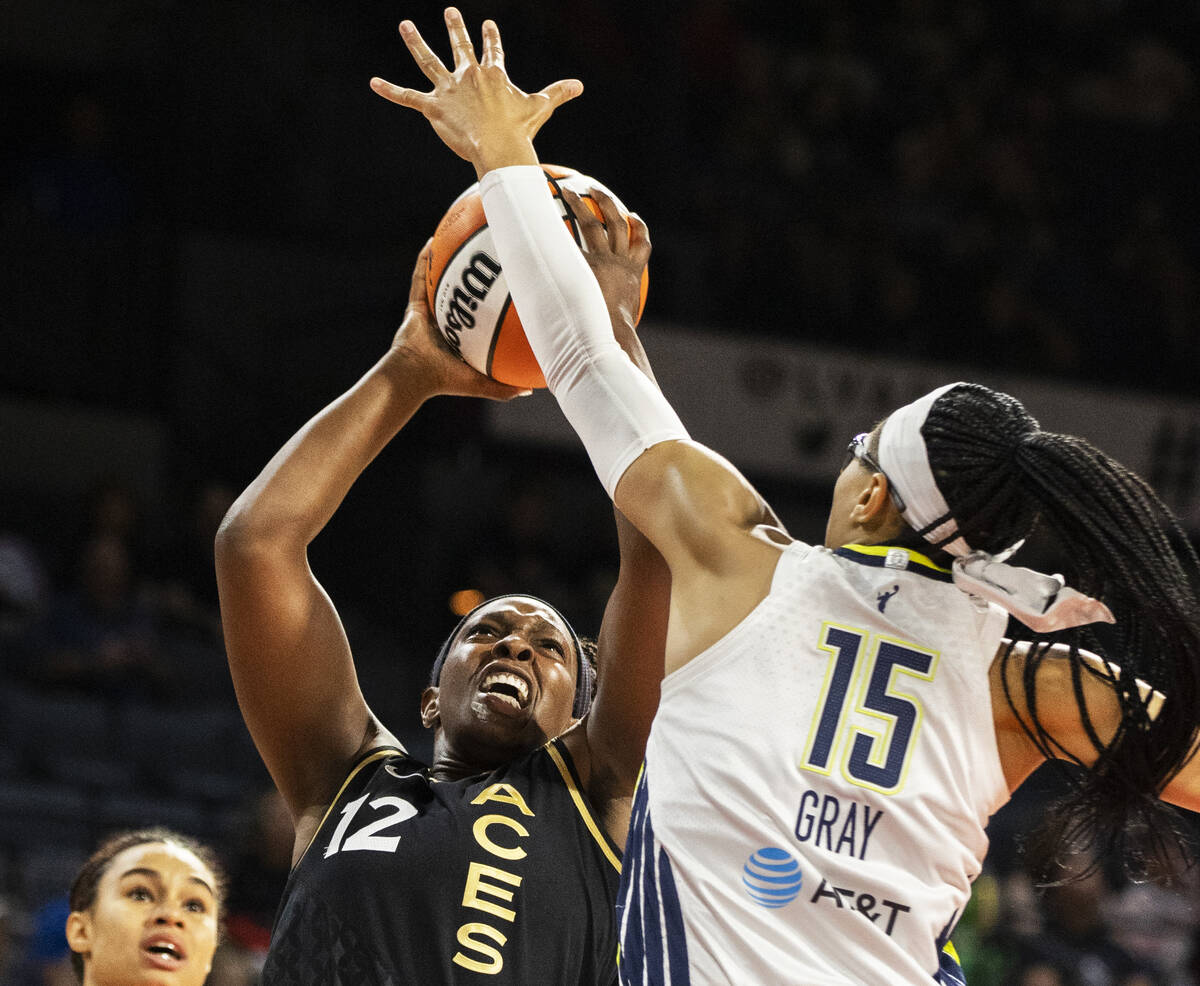 Aces guard Chelsea Gray (12) slices to the rim past Dallas Wings guard Allisha Gray (15) in the ...