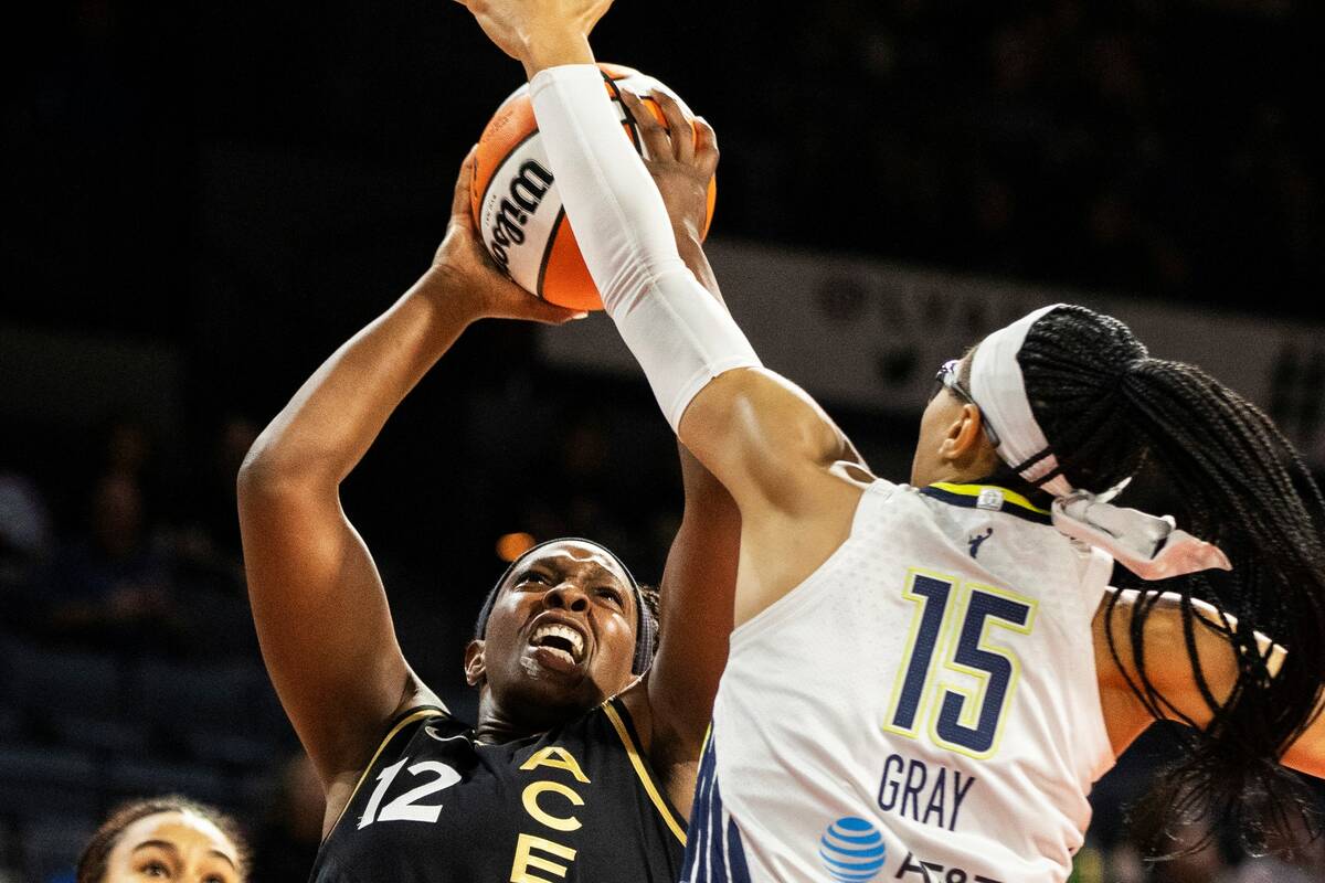 Aces guard Chelsea Gray (12) slices to the rim past Dallas Wings guard Allisha Gray (15) in the ...