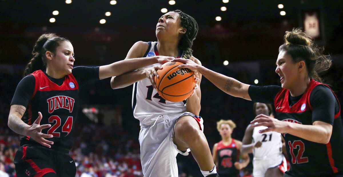 Arizona Wildcats forward Sam Thomas (14) tries to split between UNLV Lady Rebels guard Essence ...