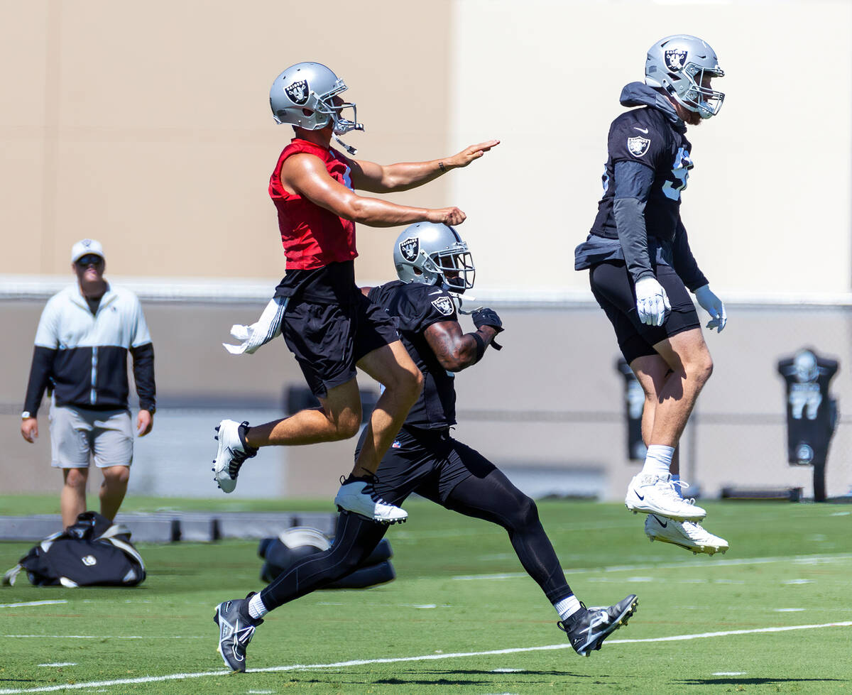 (From left) Raiders quarterback Derek Carr (4) catches some air beside defensive end Clelin Fer ...