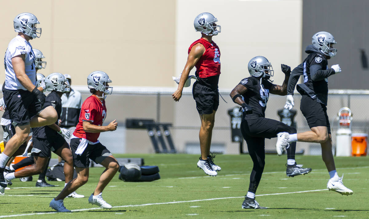 Raiders quarterback Derek Carr (4, center) catches some air during minicamp practice at the Rai ...