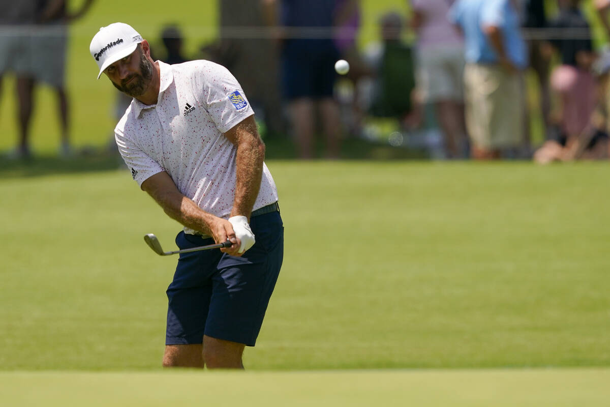Dustin Johnson chips to the green on the first hole during a practice round for the PGA Champio ...
